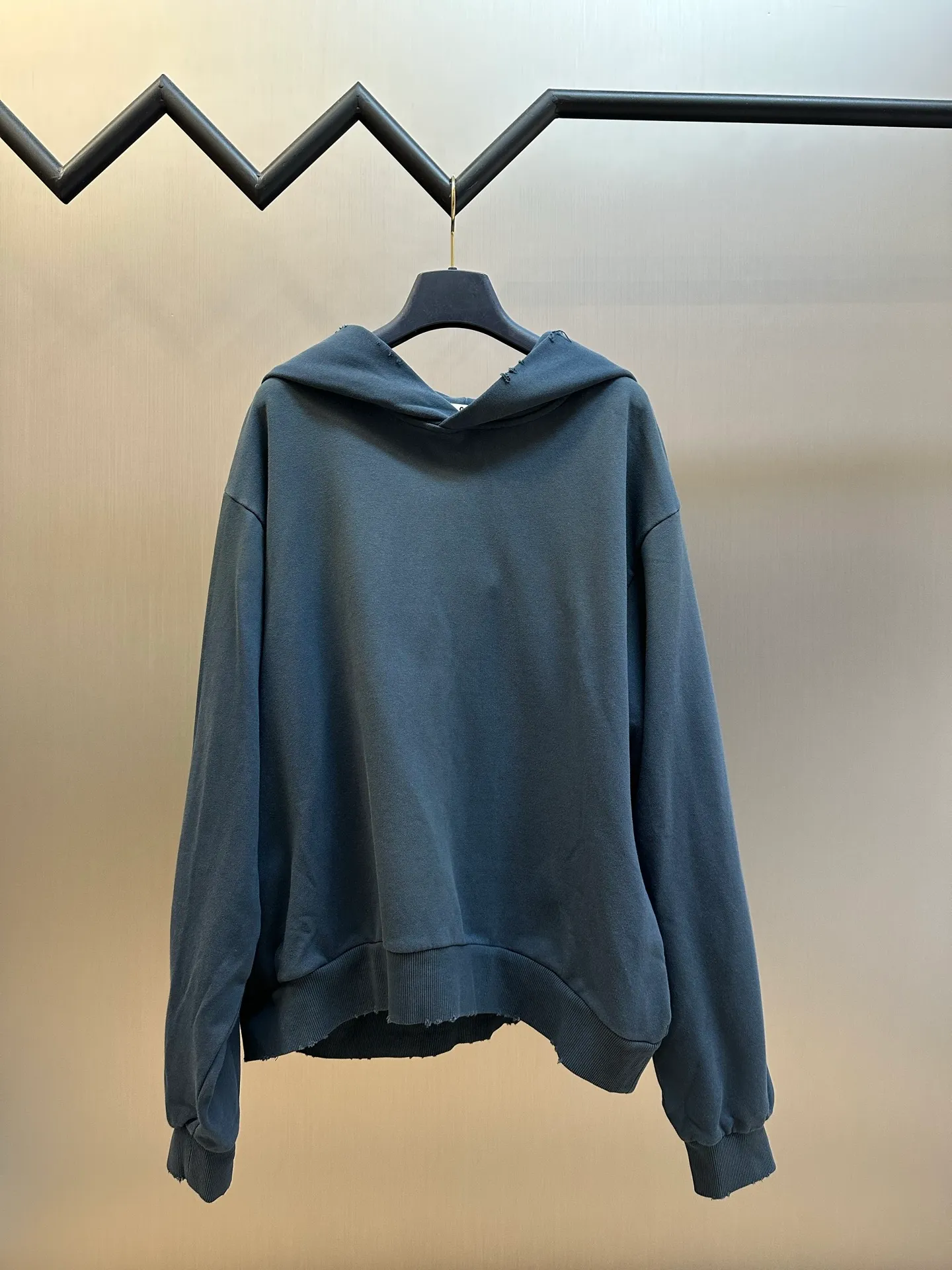 Ac spray-painted distressed logo hooded sweatshirt (blue) is made of custom air-oxygen soft cotton blend fabric, with a loose and relaxed silhouette. The raw edge hem outlines the casual lines of Retro. The Ac Studios STOCKHOLM logo on the back is quietly embellished, and the Classic logo is low-key engraved with the brand's genes. It exquisitely combines street luxury texture with Scandinavian minimalist aesthetics. Adopting the glue printing process, the chest printing is modified by the film screen three times. The glue liquid paint is used to print the pattern on the fabric and the fabric is baked to fix the printing pattern. The gradient distressed spray process sprays dyes of different colors on the surface of the fabric to achieve rich color changes under different lights and increase the visual layering. Many parts of the body of the garment are worn and worn at regular intervals, with manual brush marks added to add texture and depth to the surface of the garment to imitate the texture of natural wear and tear size: s m l xl